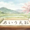 日本の美しい里山の風景を背景に、あいうえおの文字が書かれた巻物が机に置かれている水彩画風のイラスト。